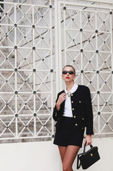 a lady wears a black crop jacket with black shorts